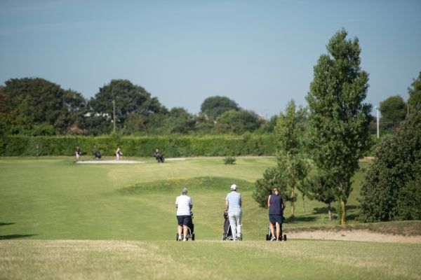 three people playing a round of golf